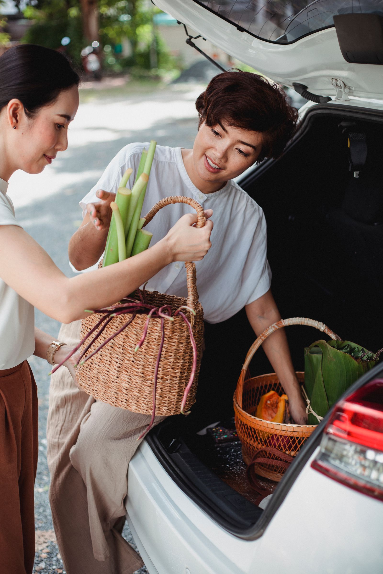 Travelers loading grocery baskets into the trunk of a rental car