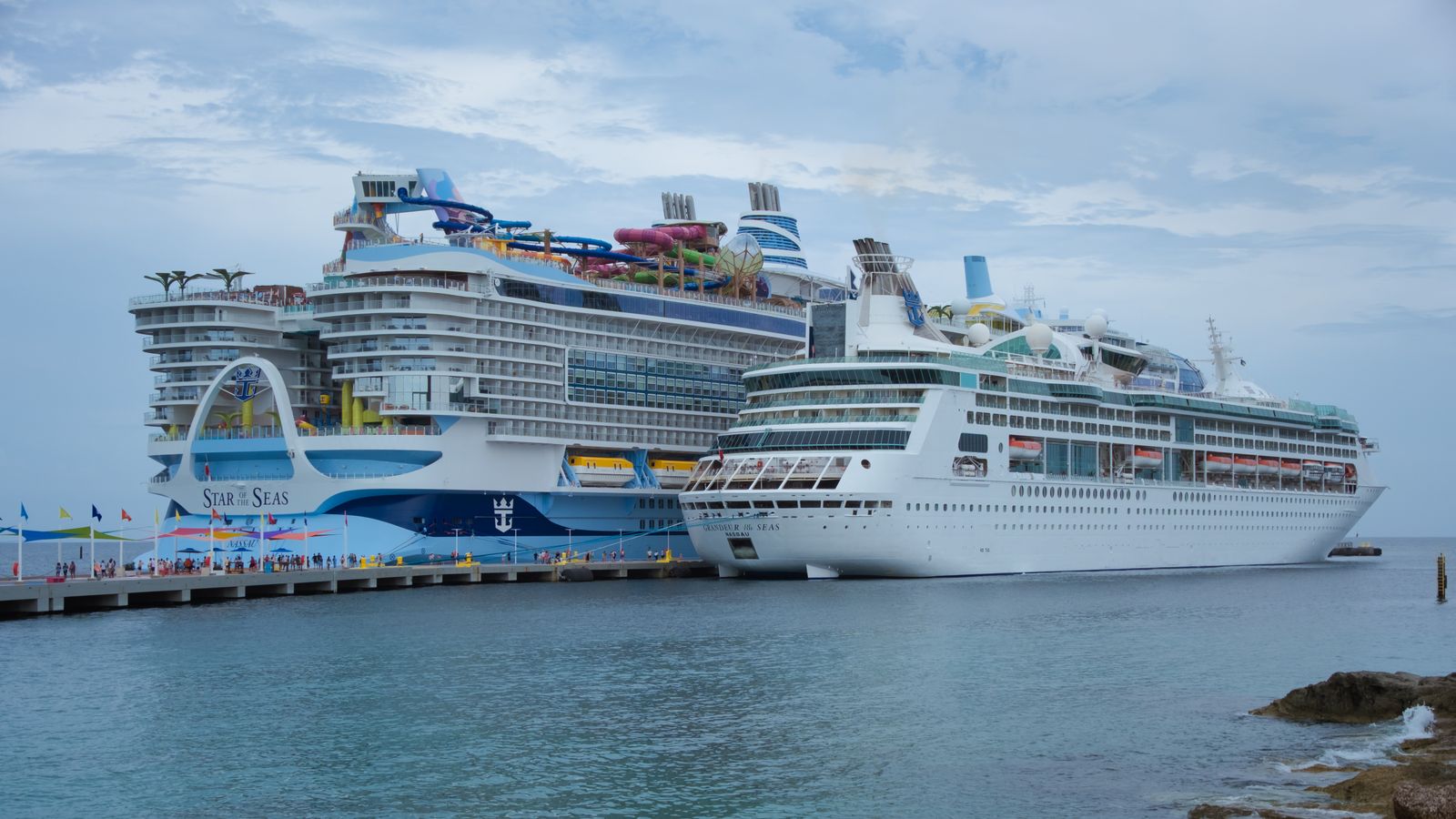 Two cruise ships docked at a tropical port pier