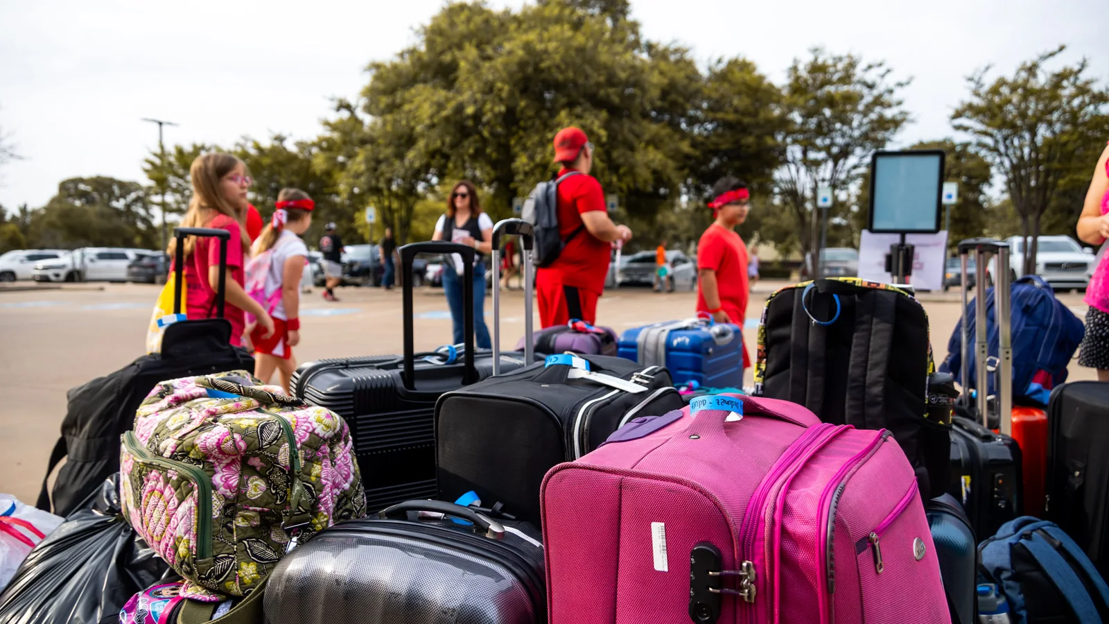 Suitcases for a large Maui travel group arranged together in a parking area
