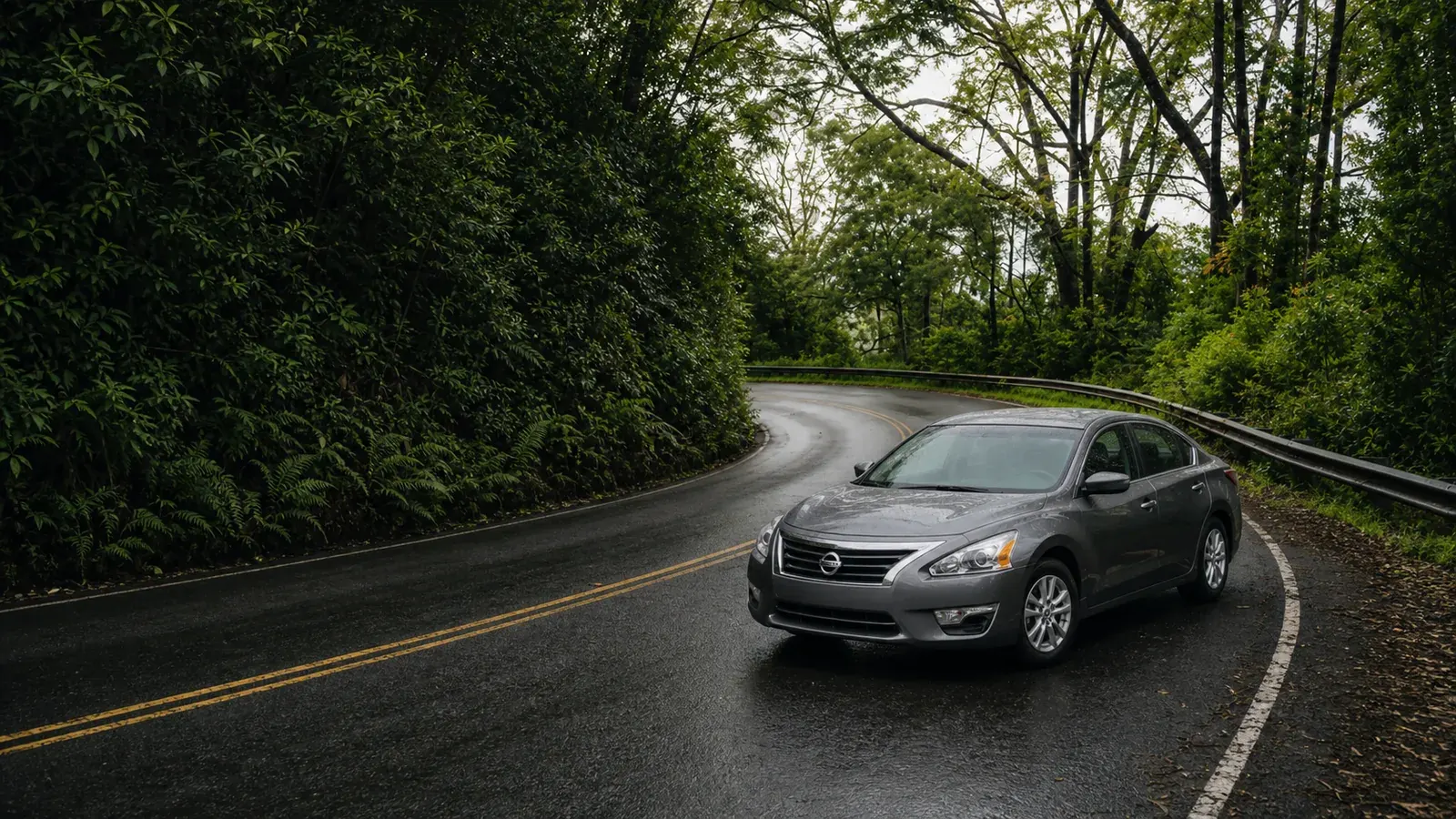 Gray local rental sedan on a winding Road to Hana forest road