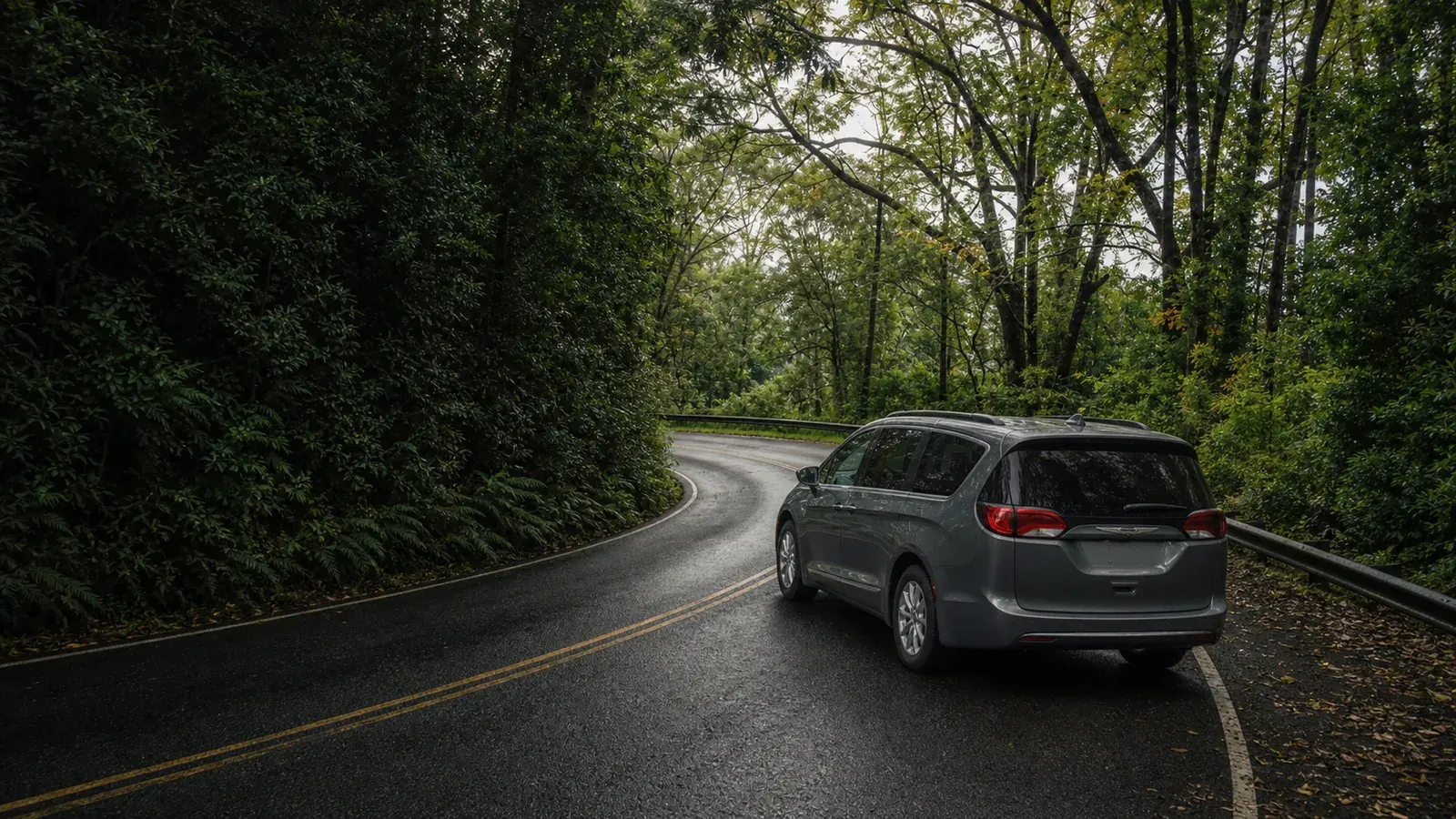 Gray minivan on a winding Road to Hana forest road