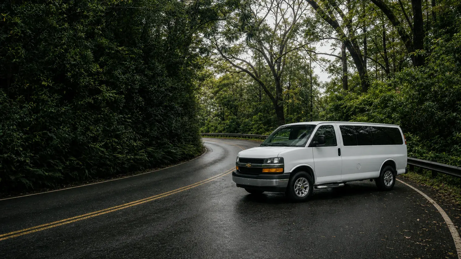 White passenger van on a winding Road to Hana forest road